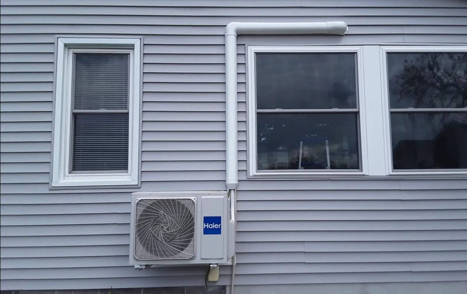 Outdoor ductless heat pump unit installed beside a home